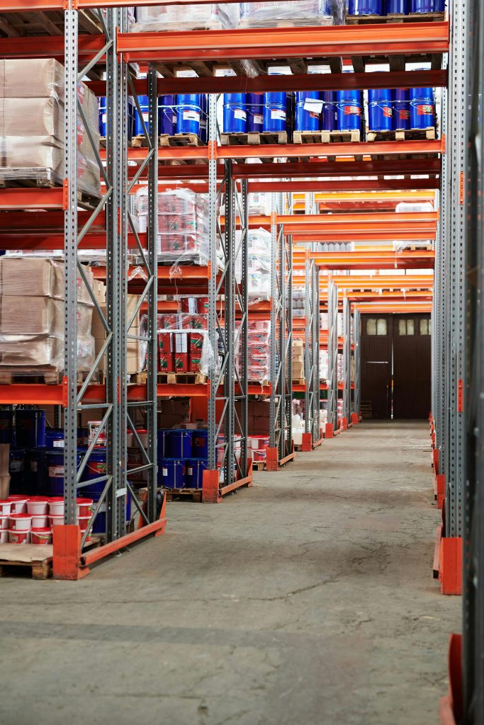 pexels-photo-4483609-4483609 Industrial warehouse interior with organized shelves stacked with packages and goods.